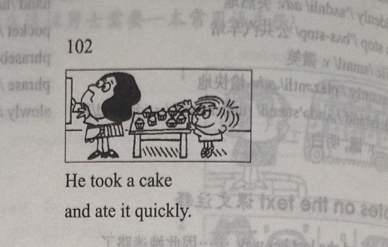 A man takes a cake from a table where a boy is eating quickly.