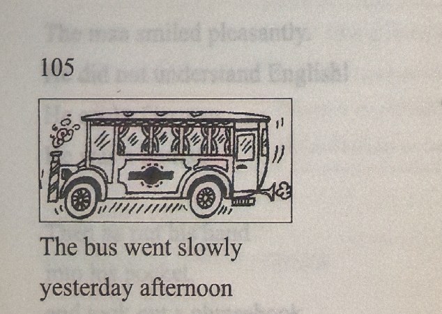 A vintage bus with passengers inside moves slowly down a street.